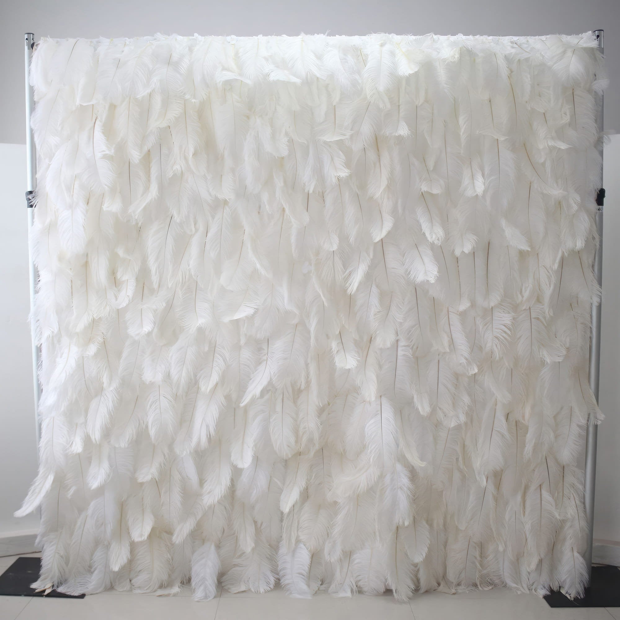 This image showcases a luxurious white feather backdrop by Valar Flowers. Densely packed with soft, pristine white feathers, it creates a plush, ethereal, and elegant display. The feathers&