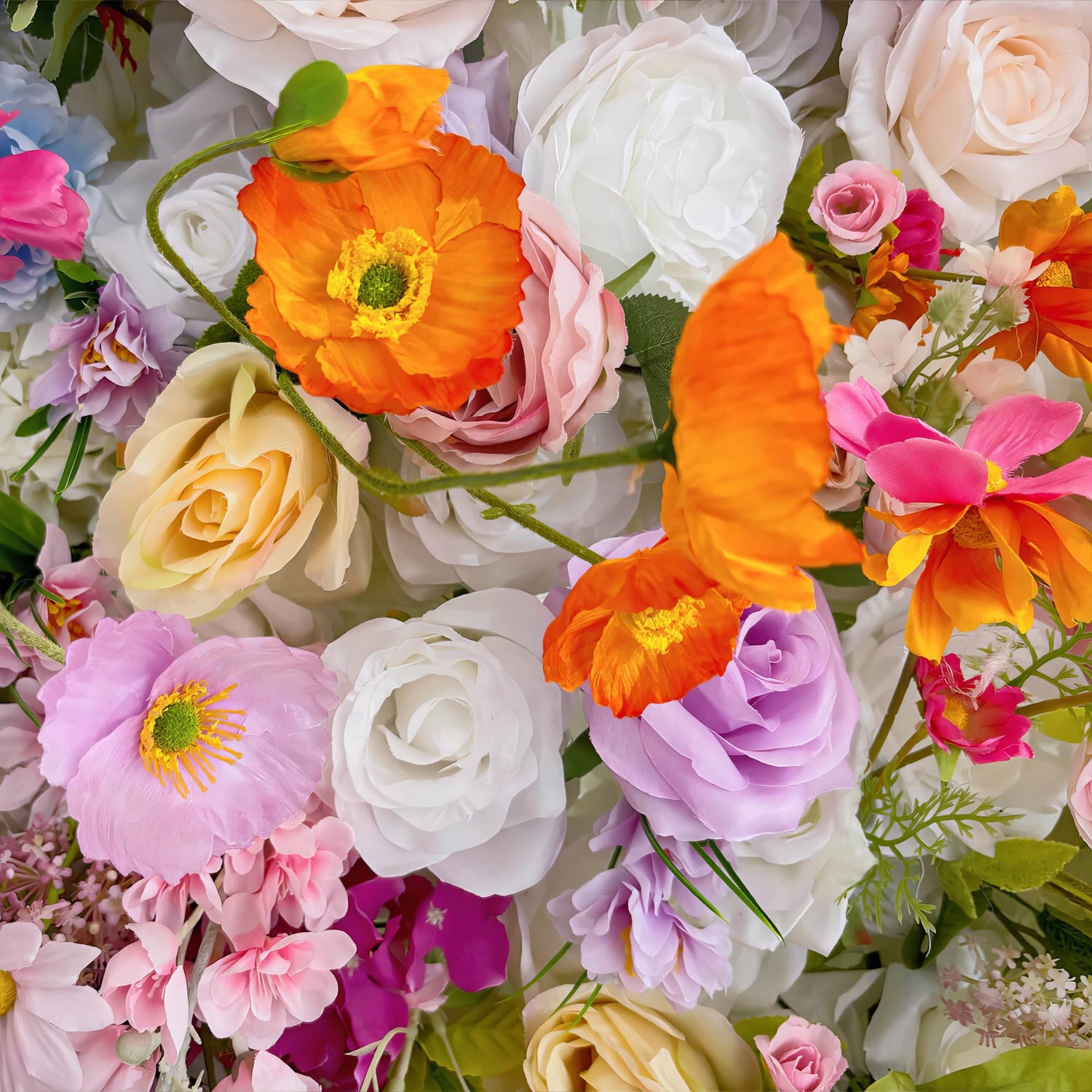 This image showcases a vibrant and lush arrangement of artificial flowers. The color palette is diverse, featuring soft pastels like pink, lavender, and cream, as well as bold hues such as orange. Prominent flower types include roses, poppies, and delicate, multi - petal blooms. The overall style is whimsical and colorful, creating a cheerful and eye - catching display that exudes a sense of celebration.