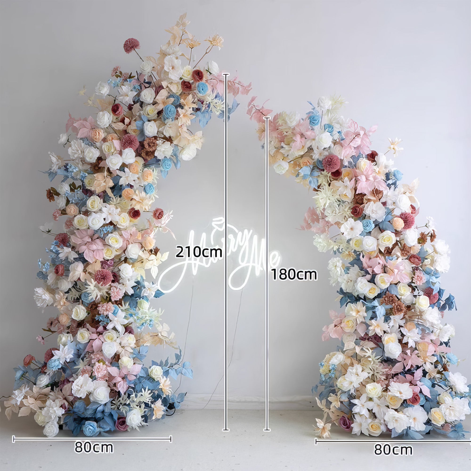 This flower - laden arch features a pastel palette of soft blues, pinks, whites, and muted earthy tones. Comprising roses, dahlias, and various blooms, it exudes a romantic, dreamy style. Measuring 210cm at the tallest part and 80cm at the base, it&