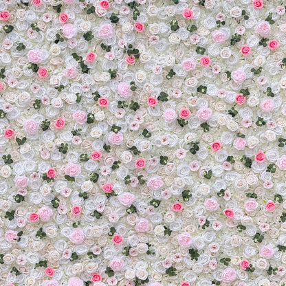 This photo showcases a stunning floral wall, likely by ValarFlowers, featuring artificial roses in soft pink and white hues, interspersed with greenery. The dense arrangement creates a romantic and elegant ambiance, perfect for weddings or other formal events. The realistic appearance of the faux flowers adds a touch of timeless beauty, making it an ideal backdrop for capturing memorable moments with a dreamy, celebratory atmosphere.