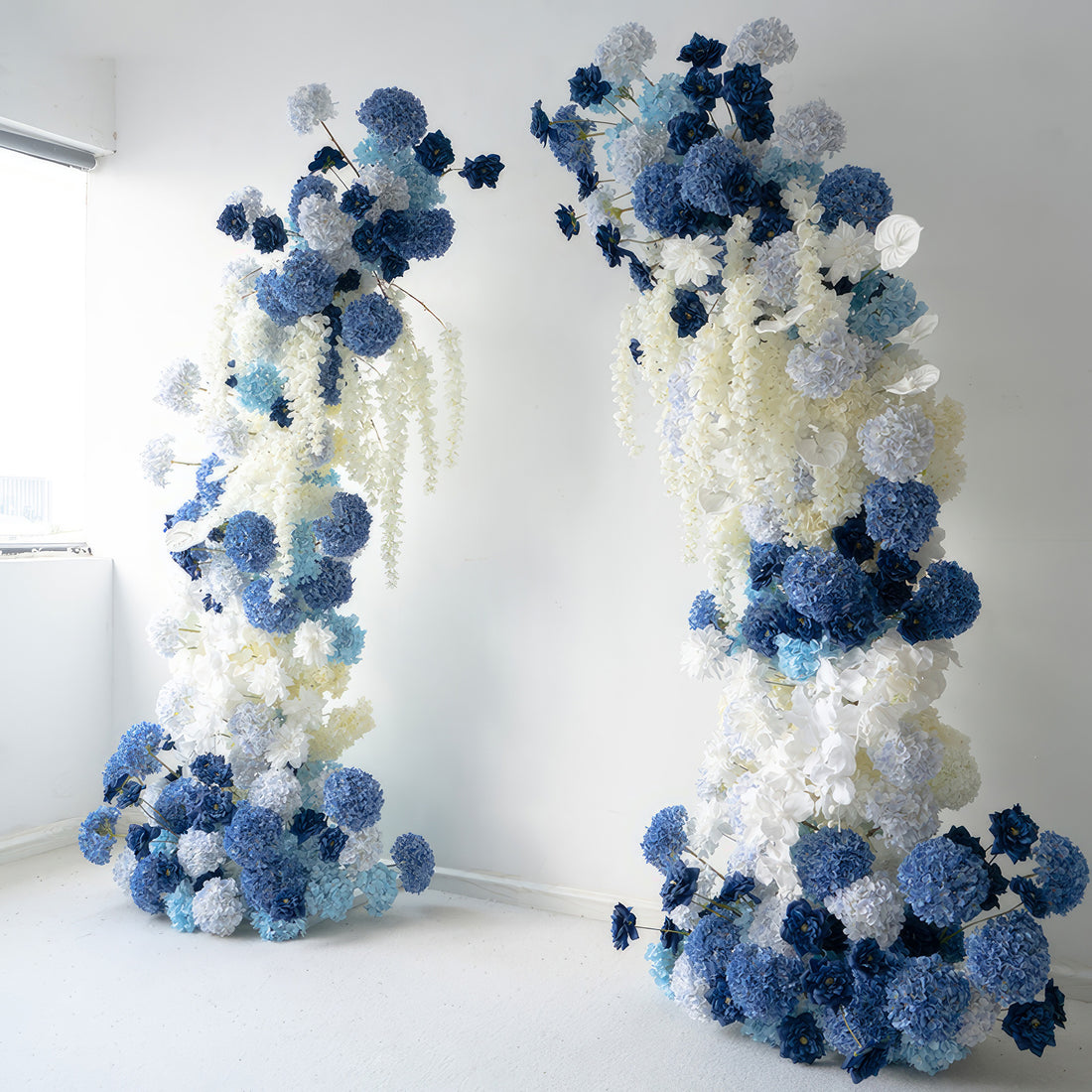 This flower - adorned arch presents a stunning combination of deep blues, light blues, and whites. Abundant with hydrangeas and other blossoms, it conveys a serene and elegant style. Perfect for weddings, events, or photo - ops, it adds a touch of sophistication to any occasion.