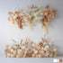 This image features artificial flower arrangements in soft white, peach, and hints of gold - toned foliage. There are hydrangea - like blooms and palm - like fronds. The style is elegant and modern, perfect for event decor. 