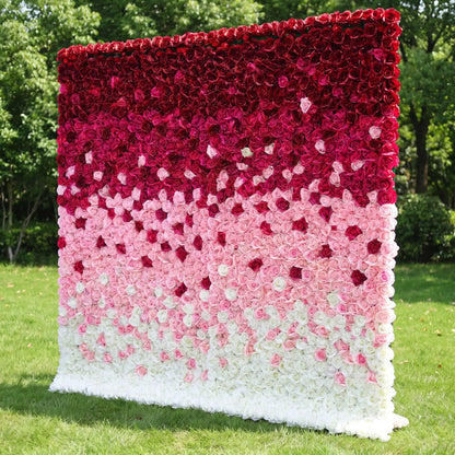 Gradient ombre artificial rose flower wall with seamless deep burgundy, blush pink and creamy white layered blooms, placed on a lush outdoor lawn. This reusable, zero-maintenance floral backdrop features dense full coverage for rich romantic texture. Perfect for wedding photo booths, bridal showers, boutique retail displays and brand content shoots, delivering eye-catching layered color gradients for elegant social media-ready event decor.