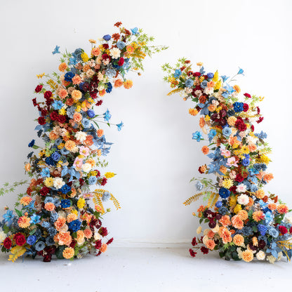 This image showcases a vibrant artificial floral arch. The color palette is rich and diverse, including shades of blue, orange, yellow, red, and various pastel tones. It features a mix of different - sized flowers like roses and daisy - like blooms. The overall style is lively and eye - catching, perfect for a festive or celebratory event. 
