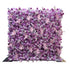 This image features a flower wall densely packed with artificial flowers. Predominant flowers include roses in various shades of purple, lavender, and light pink, interspersed with clusters of smaller white and pink blossoms. The color palette creates a harmonious blend of cool tones, giving it a romantic and elegant style, perfect for events like weddings or photo - backdrops. 