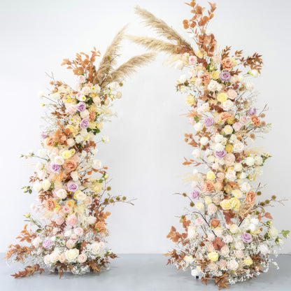 This is a beautifully crafted floral arch made of artificial flowers. It combines soft pastel tones like pink, lavender, and cream with warm earthy hues from the brownish - orange leaves and pampas grass. The arch exudes a romantic, natural, and bohemian style, perfect for weddings or garden - themed events. 