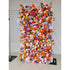 This image showcases a 1.2x2.4m(4*8ft) vibrant floral wall adorned with a rich variety of artificial flowers. The colors are a vivid mix of bright orange, soft pink, deep red, delicate blue, creamy white, and sunny yellow. Flower types include roses, daisies, and other assorted blooms, creating a lively and cheerful style. The dense arrangement is eye - catching, perfect for events or photo backdrops. 