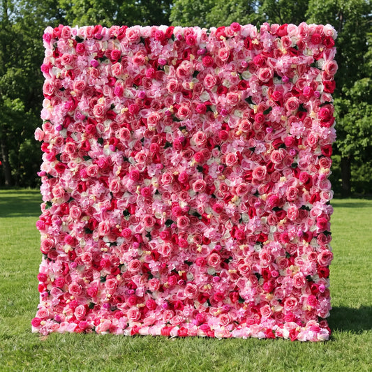 Vibrant full-panel artificial rose flower wall with rich gradient deep burgundy, fuchsia magenta and light pink roses, accented with tiny white filler blossoms and subtle green foliage, displayed on a lush sunlit lawn. This reusable, weather-resistant floral backdrop delivers bold romantic depth, ideal for wedding photo booths, anniversary parties, boutique retail displays and vivid red-pink themed social media content shoots for striking event decor.