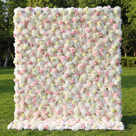Soft airy artificial flower wall covered with creamy white hydrangeas, pale blush roses and subtle pale green filler blooms, set on a bright sun-dappled green lawn. This reusable, low-maintenance floral backdrop features full fluffy layered texture, ideal for wedding photo booths, baby showers, bridal brunches, boutique shop displays and gentle pastel aesthetic social media shoots for light, dreamy event decor.