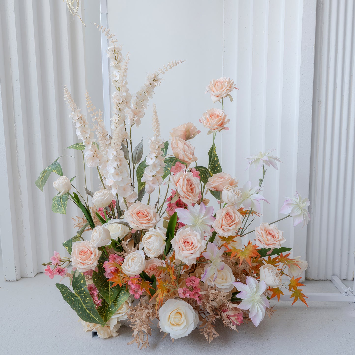 This image features an artificial flower arrangement with roses as the main type, along with other blooms. Colors include soft peach, white, and touches of pink and orange. The style is elegant and natural - looking. 