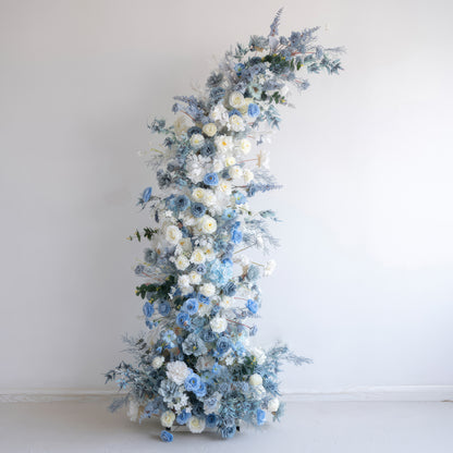 This is an elegant floral arch crafted from artificial flowers. It features a color combination of soft white and various shades of blue. With roses and other blooms, along with blue - toned foliage, it presents a serene, sophisticated, and dreamy style. 
