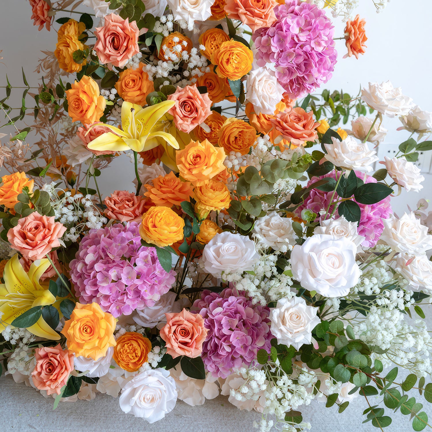 This is a vibrant and eye - catching flower arrangement. It combines orange and peach - toned roses, bright yellow lilies, large clusters of purple hydrangeas, and white roses. There are also delicate white baby&