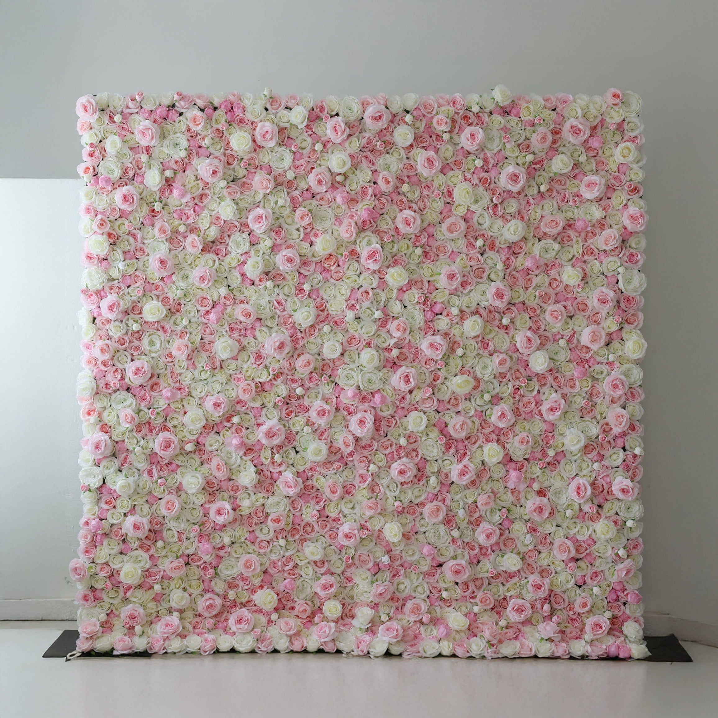 This is a large, rectangular artificial flower wall backdrop, densely covered with a lush mix of soft pink, white, and pale green roses and peonies. It stands upright indoors against a plain white wall, creating a romantic, elegant, and dreamy display perfect for weddings, photo shoots, or special events.