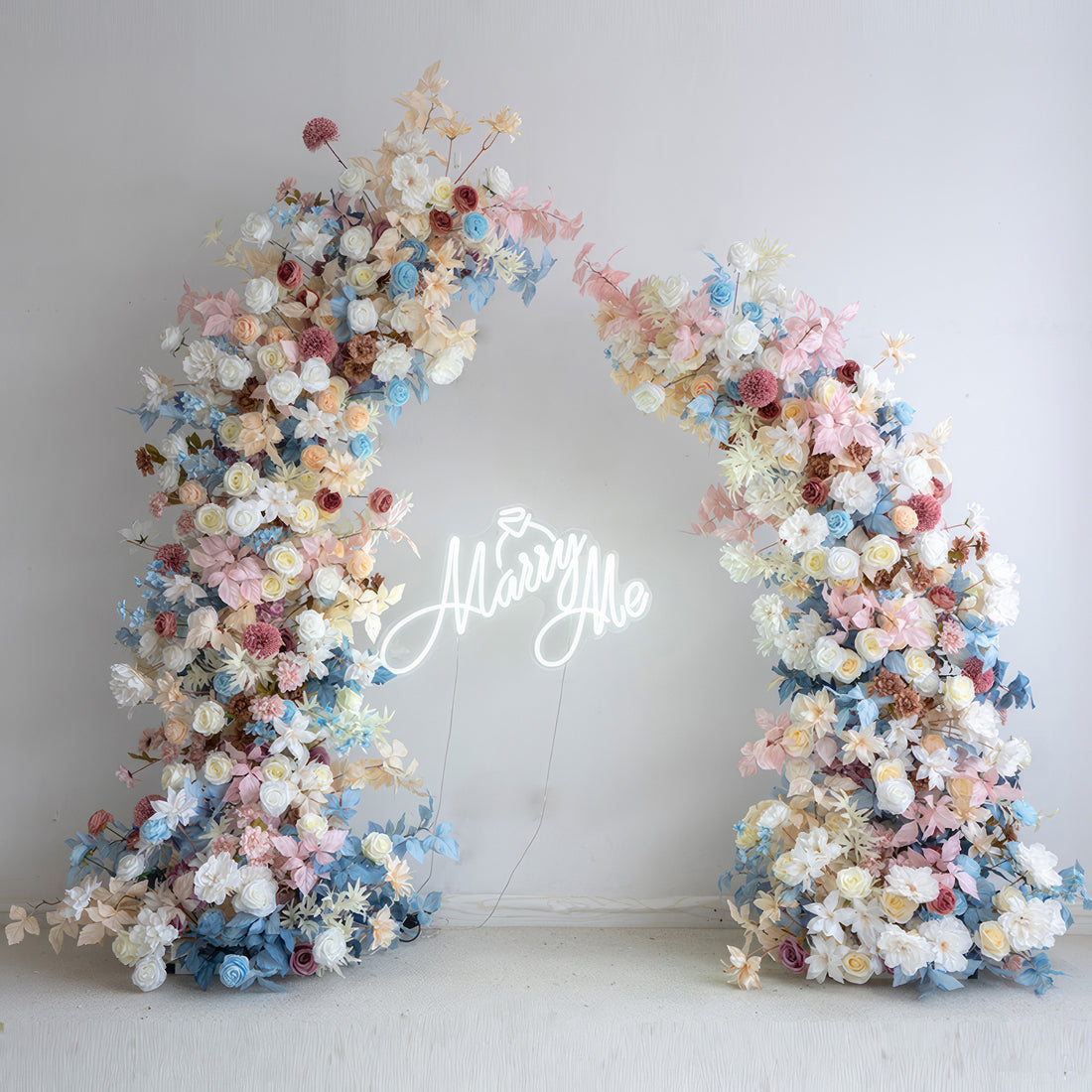 This flower arch is a visual delight, boasting a palette of soft blues, pinks, whites, and hints of earthy hues. With roses, hydrangeas and various blooms, it exudes a romantic, whimsical style, ideal for weddings, engagement parties and photoshoots.