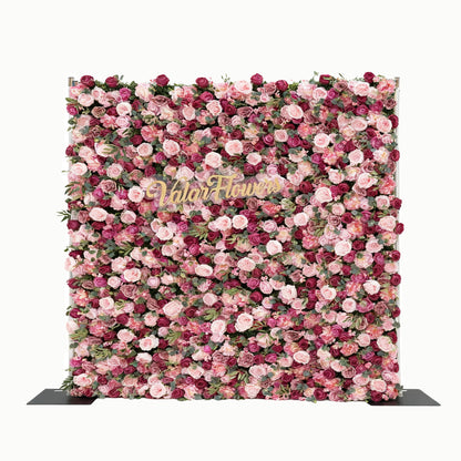 This image features a large, square floral wall composed of roses in various shades of pink and purple. In the center, golden text reads &quot;Valar Flowers&quot;. The dense arrangement of flowers creates a lush and elegant look, making it suitable for decorative purposes, such as events or photo backdrops, exuding a romantic and sophisticated atmosphere.