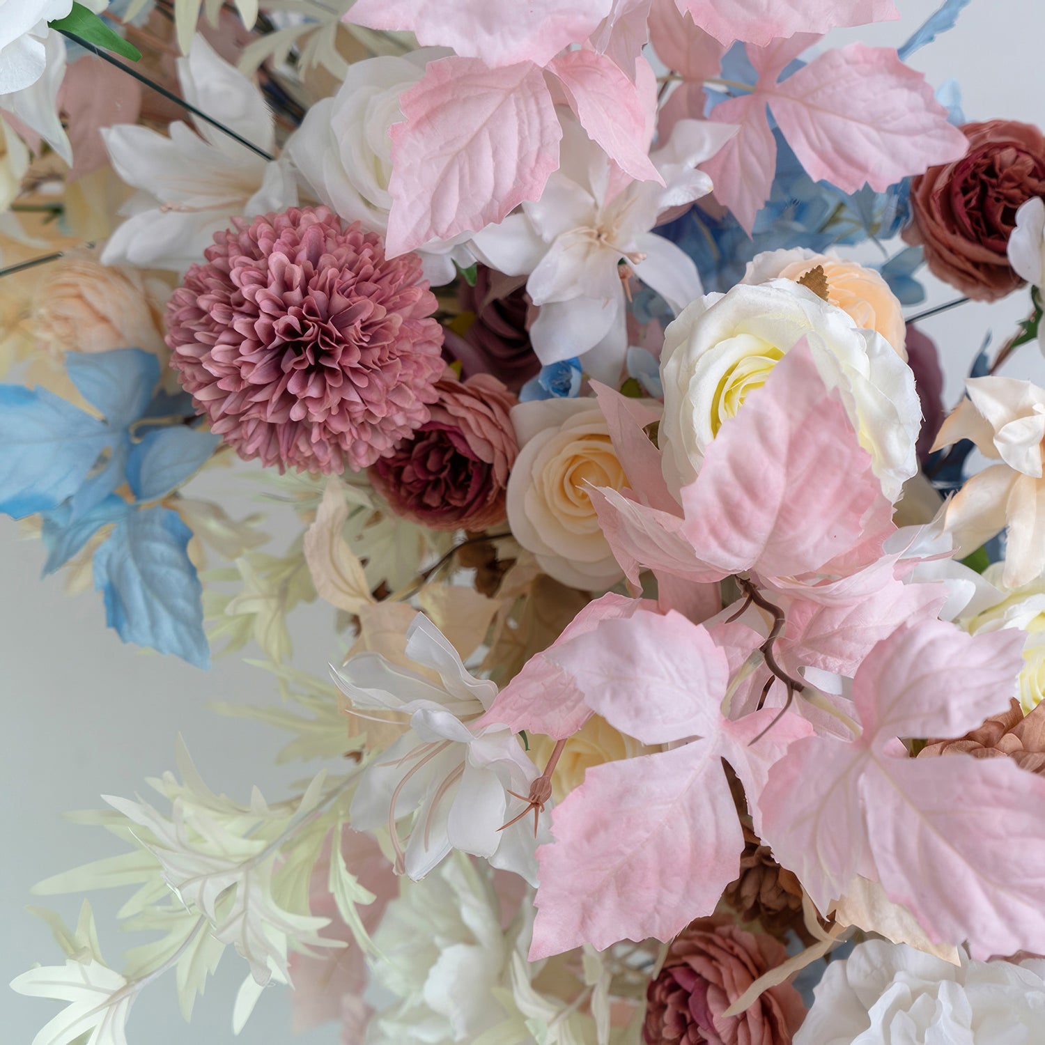 This floral cluster showcases a charming mix of colors—soft pinks, whites, blues, and hints of earthy brown. With roses, pom - pom flowers, and various leaves, it offers a delicate, romantic style. Ideal for wedding decor, party arrangements, or adding elegance to any space. 