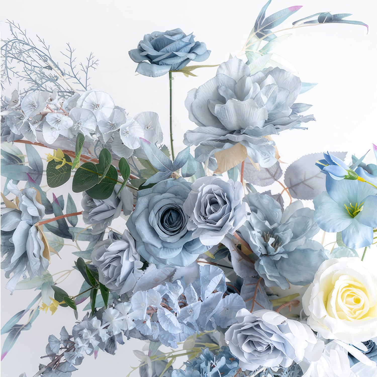This close - up showcases an artificial flower arrangement dominated by various shades of blue, from light to deep tones, along with a touch of white. It features blue roses, large blue blossoms, and some white roses. With green foliage, the style is elegant, cool - toned, and exudes a sense of calm. 