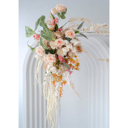 This image shows an artificial floral arrangement on an arch. It features roses, small pink flowers, and some with long white petals. Colors include soft peach, white, pink, and orange - hued leaves, in a romantic, natural style. 