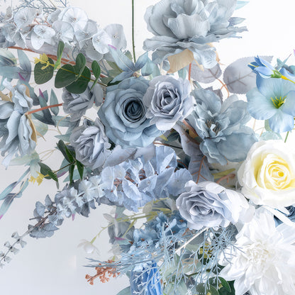 This image displays a cluster of artificial flowers in a soothing blue - and - white palette. There are various blue roses and large, light - blue blooms, along with white roses. Interspersed with green foliage, the arrangement presents an elegant, tranquil, and cool - toned style. 