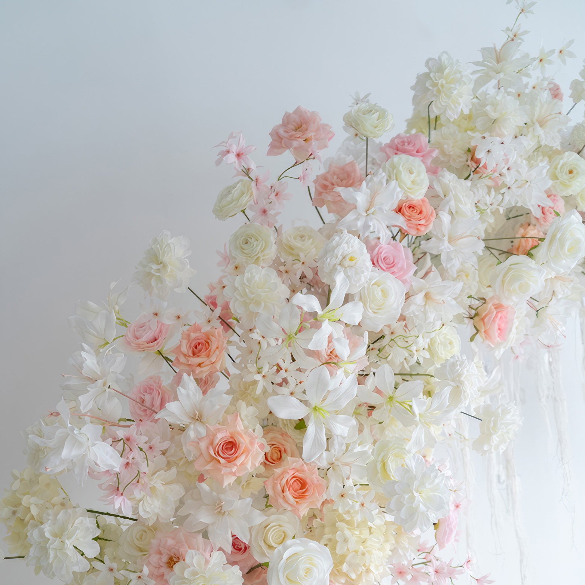 This image displays an artificial flower arrangement with roses, hydrangeas and other blooms in soft hues of white, light pink and peach. The style is romantic and dreamy, suitable for a wedding - like occasion. 