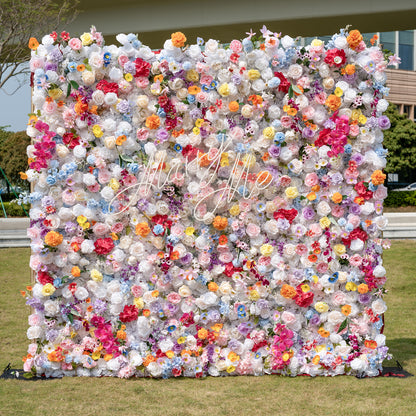 This is a stunning, dense artificial flower wall backdrop from Valar Flowers, brimming with a vibrant, rainbow-hued mix of lifelike blooms. It features creamy white roses, soft pink peonies, sunny yellow poppies, vivid orange carnations, sky-blue delphiniums, deep magenta orchids, and delicate filler flowers, creating a lush, romantic focal point perfect for outdoor weddings, proposals, engagement parties, photo booths, and luxury event decor.
