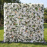 This opulent floral backdrop blends dense white blooms—roses, hydrangeas—with soft peach accents and delicate green foliage. Varied petal textures and subtle tonal gradients (ivory to warm peach) add depth, while natural sunlight enhances the lush, romantic appearance. The elegant neutral palette merges classic sophistication with organic fullness, making it a refined focal point ideal for weddings, formal events, or upscale outdoor celebrations.