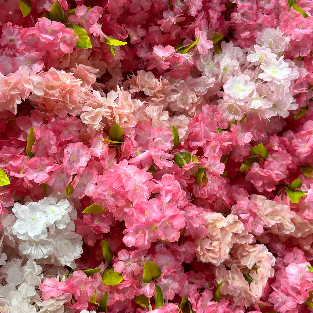 Valar Flowers premium artificial cherry blossom flower wall panel, a dense, lush floral backdrop in gradient pink and white blooms with vibrant green leaves. Perfect for weddings, spring events, bridal showers, photo booths, and party decor, this lifelike cherry blossom wall delivers a dreamy, romantic, ethereal aesthetic.