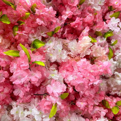 Valar Flowers premium artificial cherry blossom flower wall panel—featuring a lush, dense mix of gradient pink and ivory white cherry blossoms interwoven with vibrant green foliage. This lifelike, UV-resistant floral backdrop creates a dreamy, romantic ethereal vibe perfect for wedding ceremonies, bridal showers, engagement photos, birthday parties, and luxury event photo booth backdrops.
