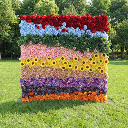 This vibrant floral backdrop features bold horizontal color blocks: deep red, sky blue, green foliage, soft pink, bright sunflowers, peach, purple, dark mauve, and orange blooms. Dense clusters of roses and sunflowers create lush, distinct layers, with natural sunlight amplifying the vivid hues. The playful, rainbow-like palette merges energetic vibrancy with organic fullness, making it a eye-catching focal point ideal for pride events, festive parties, or colorful outdoor celebrations.