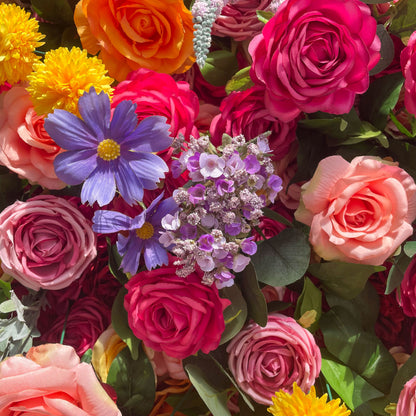 This artificial flower wall is a vibrant and eye - catching decoration. It features a rich variety of colorful flowers, including roses, daisies, and other blooms in shades of pink, orange, yellow, purple, and blue. The flowers are densely arranged with green leaves, creating a lush and lively appearance. It is perfect for adding a festive and romantic atmosphere to events.
