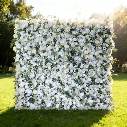This image showcases a stunning floral wall by Valar Flowers, set outdoors on a lush green lawn. It features a dense arrangement of artificial flowers in soft shades of white and cream, interspersed with lush green foliage. The meticulously crafted blooms create a lush, elegant, and visually soothing display. Bathed in sunlight, this floral wall is perfect for adding a touch of timeless beauty to events or spaces, exuding a refined and sophisticated atmosphere.