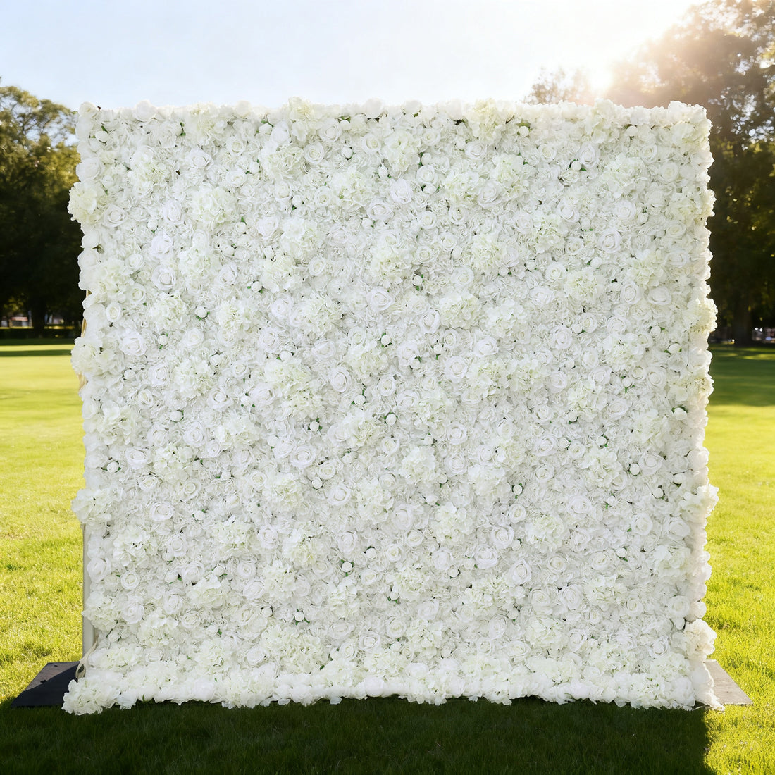 This image showcases a large, square floral wall outdoors on a lush green lawn. It&