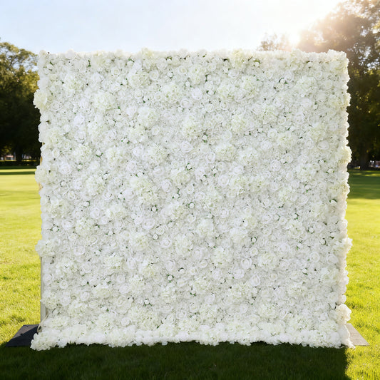 This image showcases a large, square floral wall outdoors on a lush green lawn. It's densely covered with pure white flowers, creating a clean, elegant, and serene display. Bathed in sunlight, with trees and a bright sky in the background, the scene exudes a sense of purity and natural beauty. This floral wall is perfect for decorative purposes in events or as a captivating backdrop, highlighting a harmonious blend of man - made artistry and natural surroundings.