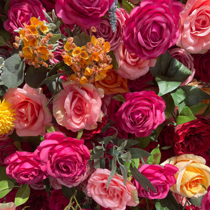 This artificial flower wall is a vibrant and luxurious decoration. It features a rich variety of colorful flowers, including roses in different hues. The flowers are densely arranged with green leaves, creating a lush and three - dimensional appearance.