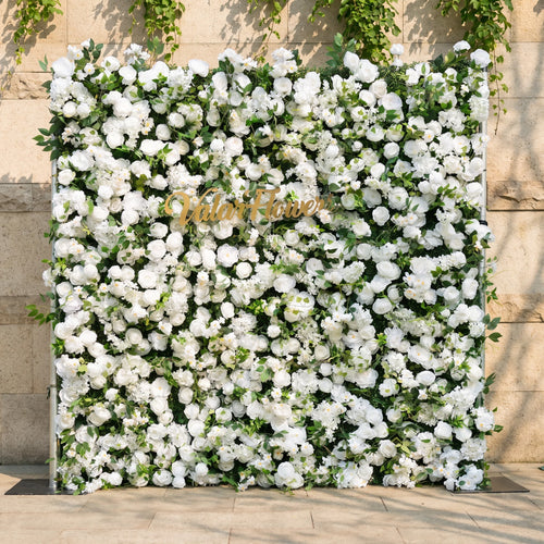 This stunning artificial flower wall backdrop by Valar Flowers features a lush, all-white design with soft roses, peonies, delicate baby’s breath, and trailing greenery, centered with a metallic "ValarFlowers" logo. Crafted with hyper-realistic, maintenance-free blooms, this reusable display creates an elegant, timeless focal point, ideal for weddings, photo booths, luxury events, and studio decor, offering a clean, romantic aesthetic perfect for professional styling.