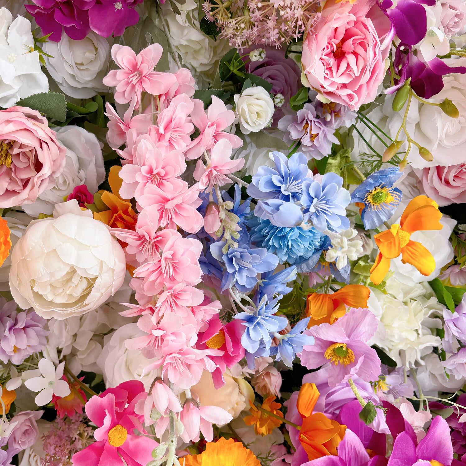 This image features a vibrant and densely packed arrangement of artificial flowers. The color palette is a delightful mix of soft pastels and bright hues, including shades of pink, blue, white, orange, and purple. Flower types include roses, peonies, and delicate, five - petal blossoms. The overall style is lush and whimsical, creating a cheerful and eye - catching display, perfect for adding a touch of floral charm to any setting. 