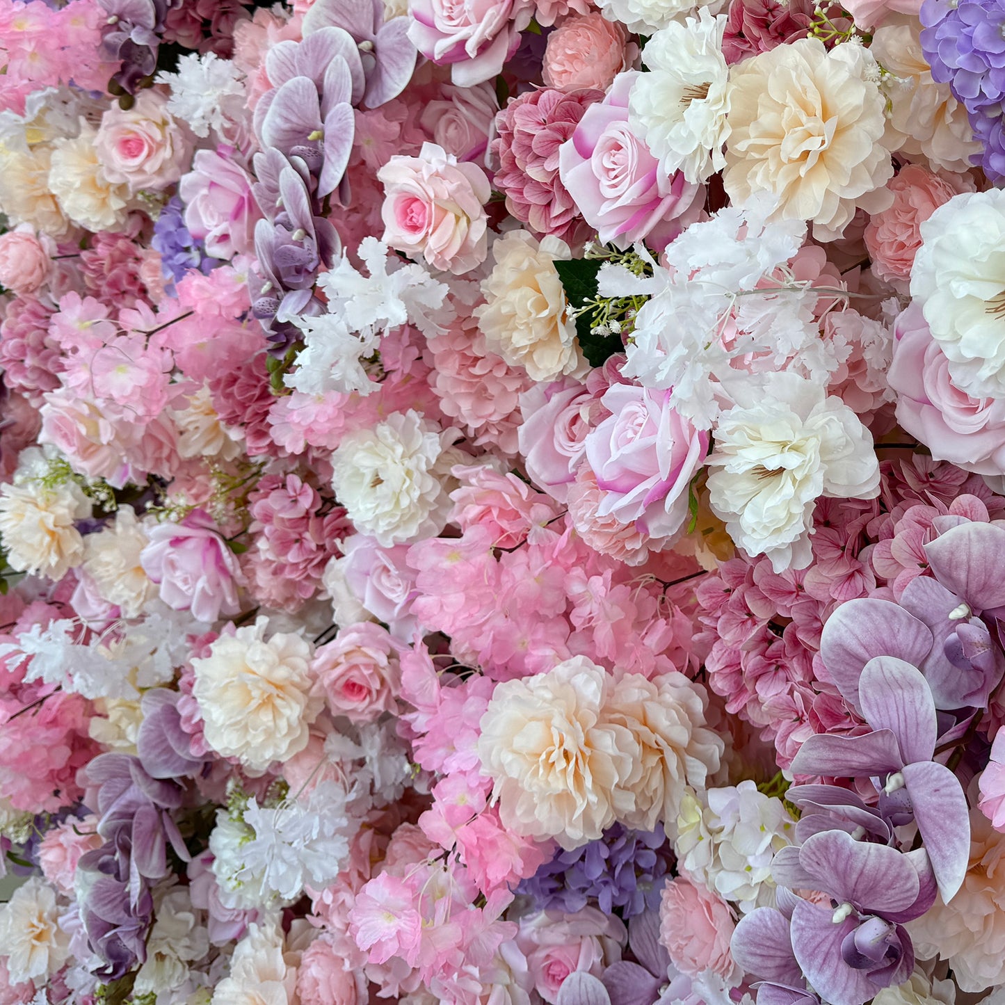 This photo from ValarFlowers showcases a lush floral arrangement. It features roses in soft pink, white, and peach tones, hydrangeas in shades of purple and pink, and delicate white flowers with small green - stemmed blooms. Purple orchids add an elegant touch. Ideal for weddings, bridal showers, or romantic events, this dreamy and colorful mix exudes charm and sophistication. 