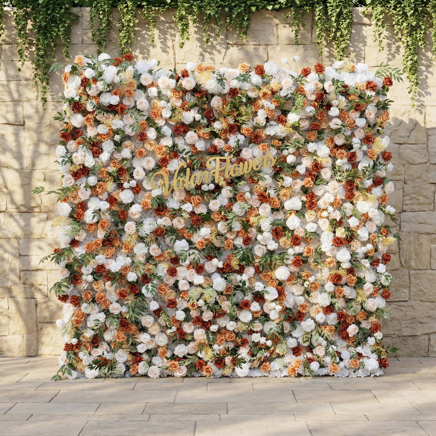 This is ValarFlowers’ premium terracotta & cream artificial flower wall backdrop, set against a sunlit stone wall with trailing ivy. It features a lush, dense arrangement of lifelike blooms: burnt orange roses, creamy white peonies, blush pink roses, and vibrant green foliage. This warm, timeless, reusable floral display creates an elegant, romantic focal point ideal for rustic weddings, fall events, photo booths, and luxury outdoor decor.