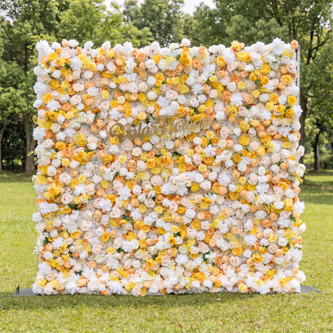 This vibrant artificial flower wall by Valar Flowers features a cheerful mix of sunny yellow, soft peach, and crisp white blooms, including roses and peonies. Set in a lush outdoor garden, its dense, layered design creates a bright, romantic aesthetic. Maintenance-free and reusable, this eye-catching backdrop is ideal for weddings, baby showers, photo booths, and summer events, adding a warm, joyful touch to any celebration.