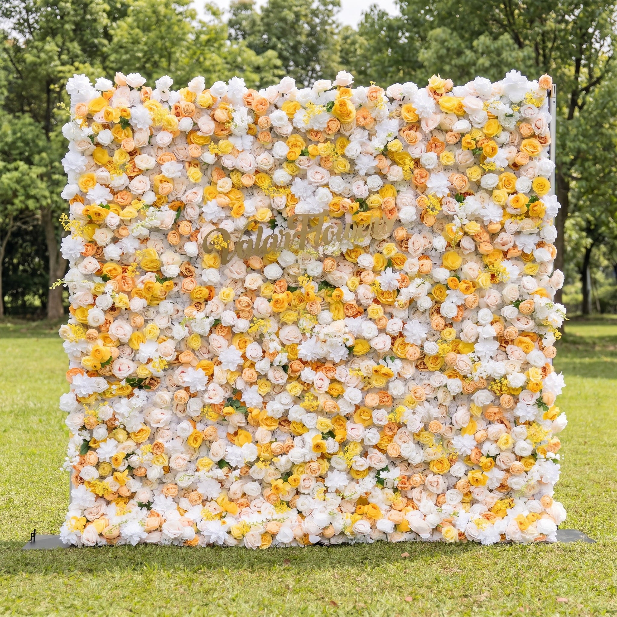 This vibrant artificial flower wall by Valar Flowers features a cheerful mix of sunny yellow, soft peach, and crisp white blooms, including roses and peonies. Set in a lush outdoor garden, its dense, layered design creates a bright, romantic aesthetic. Maintenance-free and reusable, this eye-catching backdrop is ideal for weddings, baby showers, photo booths, and summer events, adding a warm, joyful touch to any celebration.