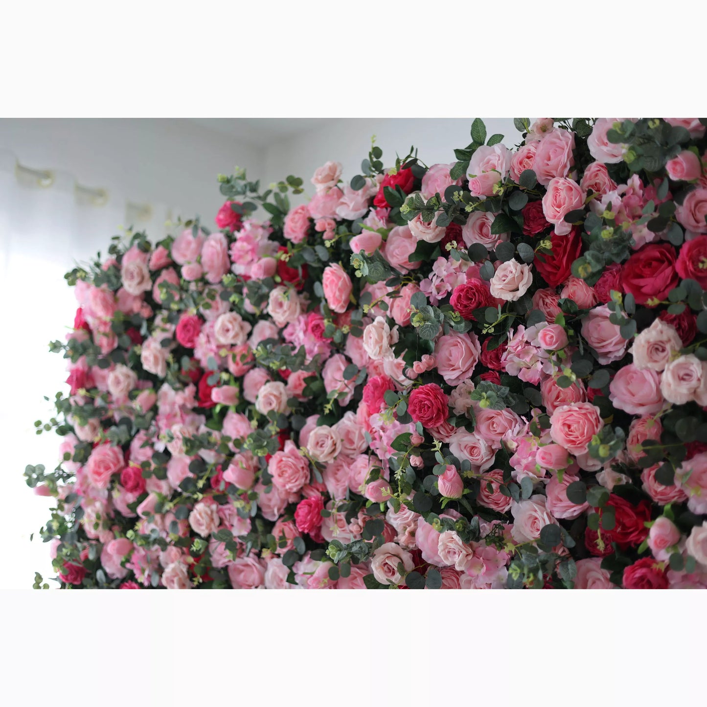 Valar Flowers' Artificial Fabric Flower Wall: A lush artificial flower wall features a mix of pink, light pink, and red roses, intertwined with green foliage. The dense, layered blooms create a romantic, vibrant, and visually appealing backdrop, perfect for adding an elegant touch to events or decor. 
