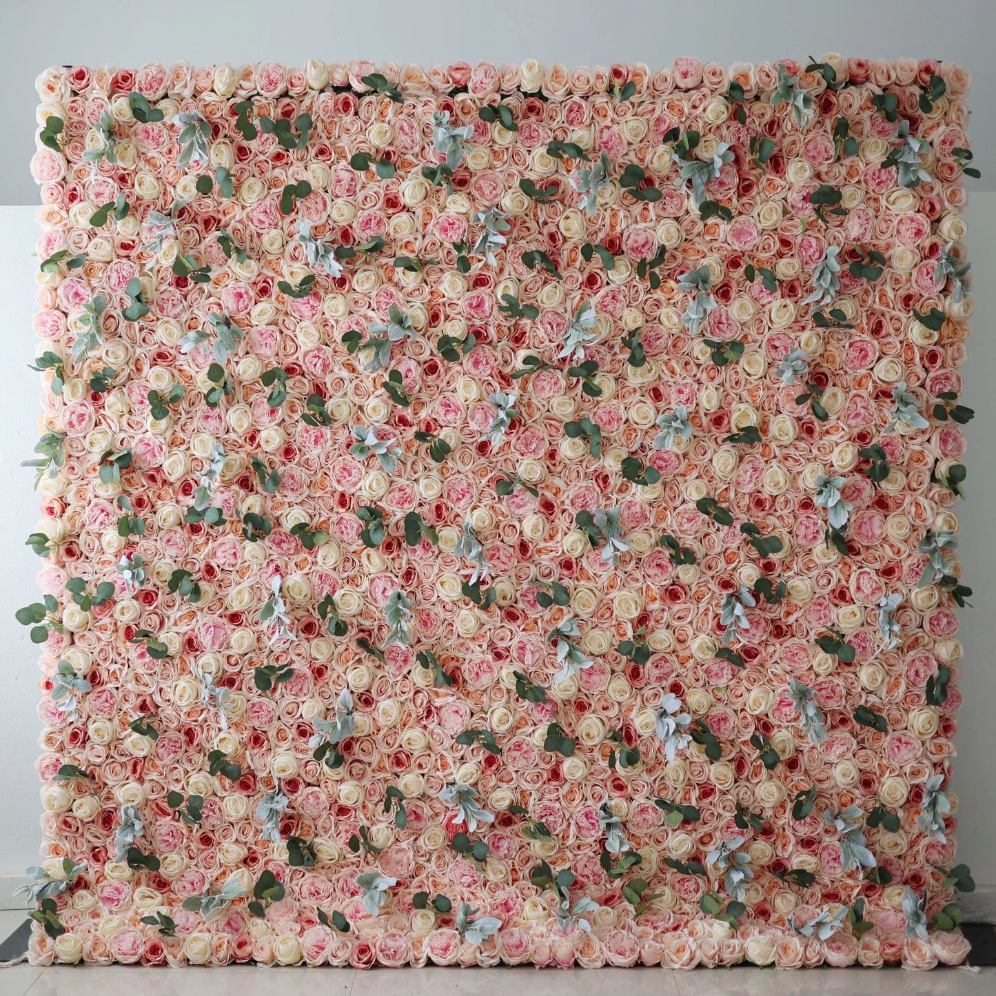 Valar Flowers' Artificial Fabric Flower Wall: A large artificial flower wall showcases a dense arrangement of soft - pink and beige roses. Interspersed are green leaves and light - toned foliage, adding texture. The uniform, lush blooms create a sophisticated, romantic backdrop, perfect for adding an elegant touch to events or decor. 