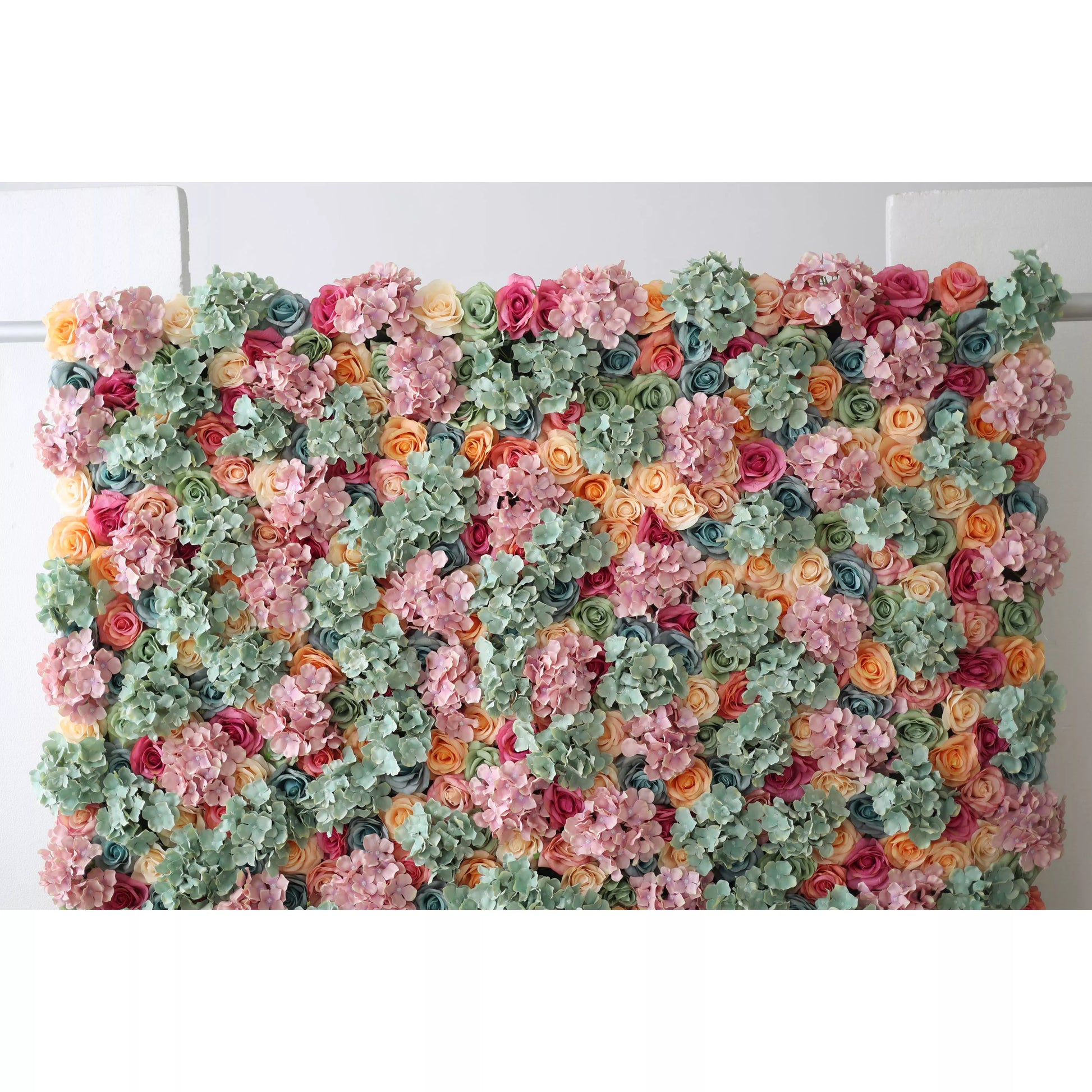 This large artificial flower wall is a vibrant, colorful tapestry. It features soft pink hydrangeas, mint - green foliage, and a variety of roses in shades like peach, coral, red, and blue. The dense, varied arrangement creates a lush, textured display, evoking natural beauty. Ideal as a backdrop for events, it adds an elegant, romantic touch, enhancing the decorative appeal with its intricate floral design. 