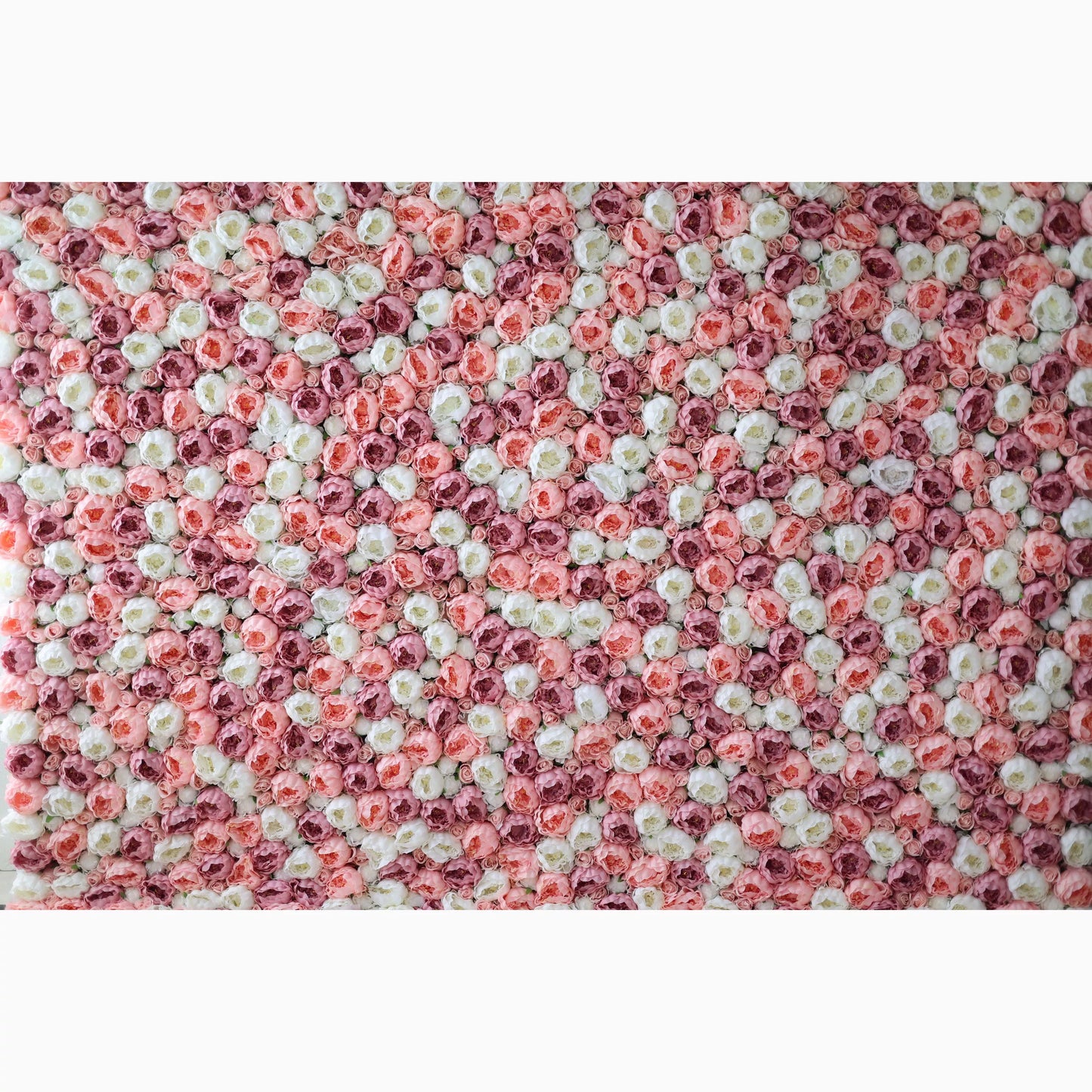 A large artificial flower wall showcases a captivating pattern of pink, white, and light pink roses. The blooms are densely packed, creating a lush, textured, and visually striking backdrop. The harmonious color blend gives off a romantic, elegant vibe, perfect for adding a decorative touch to events or spaces. 