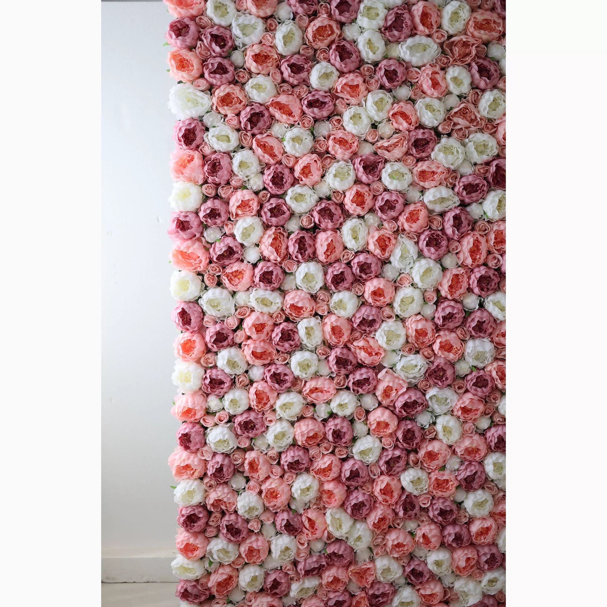 A vertical artificial flower wall showcases a beautiful arrangement of roses in soft pink, white, and deeper pink tones. The blooms are densely packed, creating a lush, textured, and romantic backdrop. Perfect for adding an elegant, dreamy touch to events or decor. 