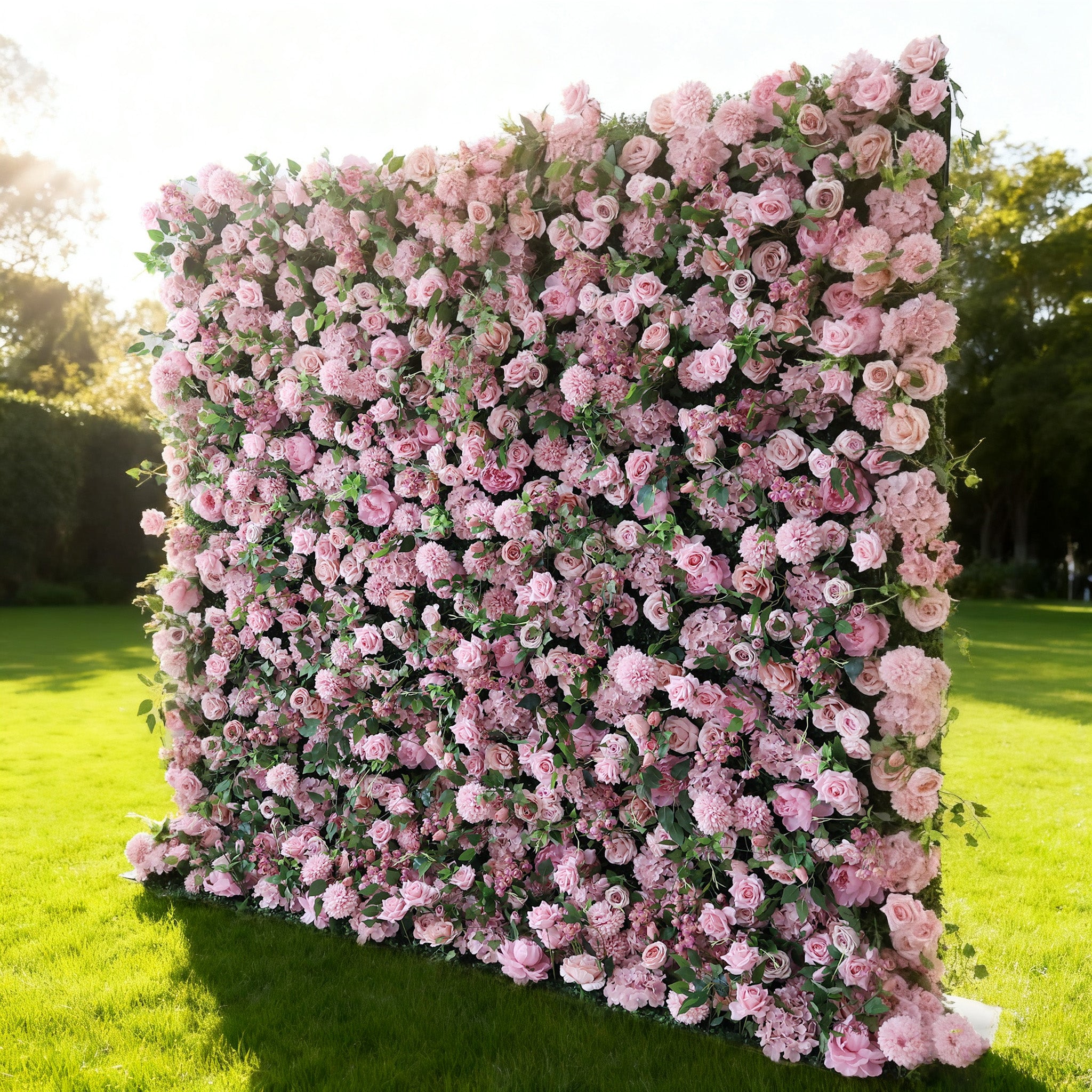 This image features a large, square floral wall outdoors on a lush green lawn. It&