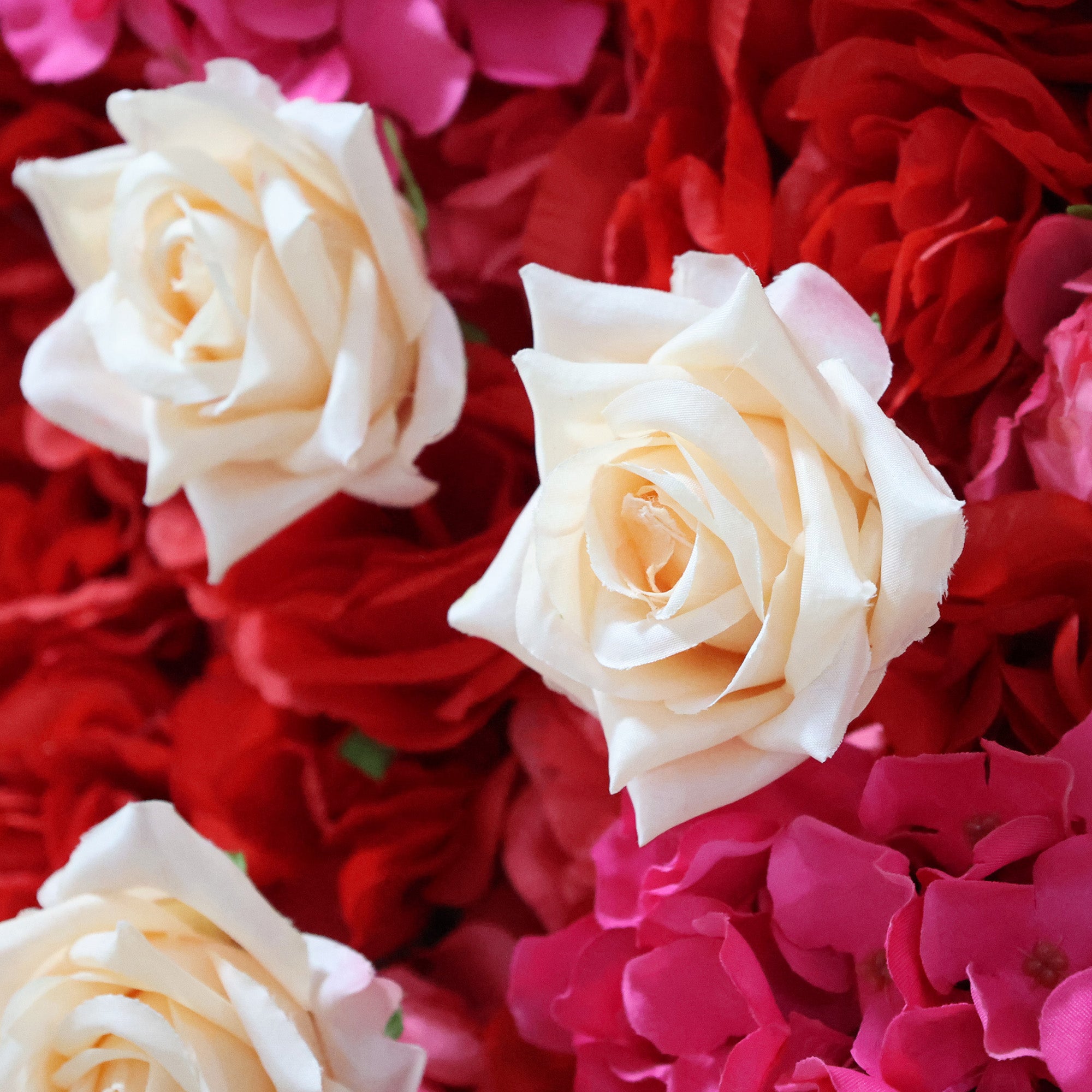 This close-up from Valar Flowers features a lush, textured floral arrangement: creamy white roses stand out against a backdrop of vibrant red hydrangeas and soft pink hydrangeas. The dense, layered design creates a rich, three-dimensional texture, evoking a bold, romantic, and naturally elegant atmosphere ideal for weddings, photo backdrops, or elegant celebrations.