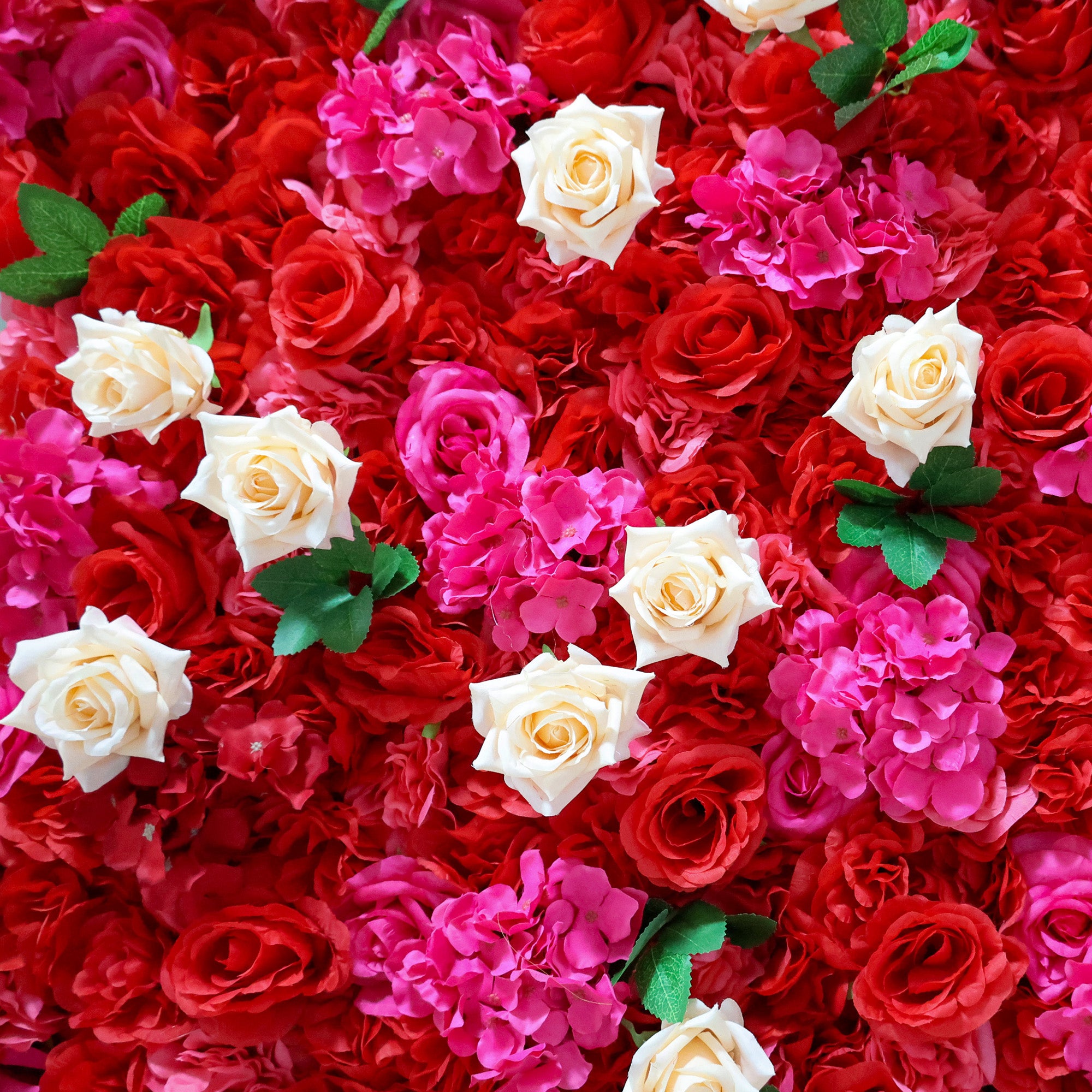 This close-up from Valar Flowers features a lush, vibrant floral arrangement. Creamy white roses stand out against a dense backdrop of deep red roses and bright pink hydrangeas, with green leaves adding contrast. The dense, layered design creates a rich, three-dimensional texture, evoking a bold, romantic, and naturally elegant atmosphere ideal for weddings, photo backdrops, or elegant celebrations.