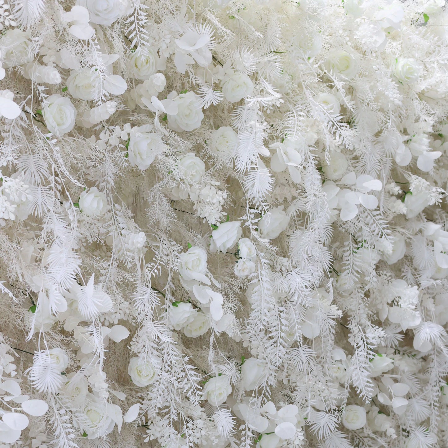 ValarFlowers white floral wall with roses peonies hydrangeas and feathered ferns for wedding backdrop photo booth event decor