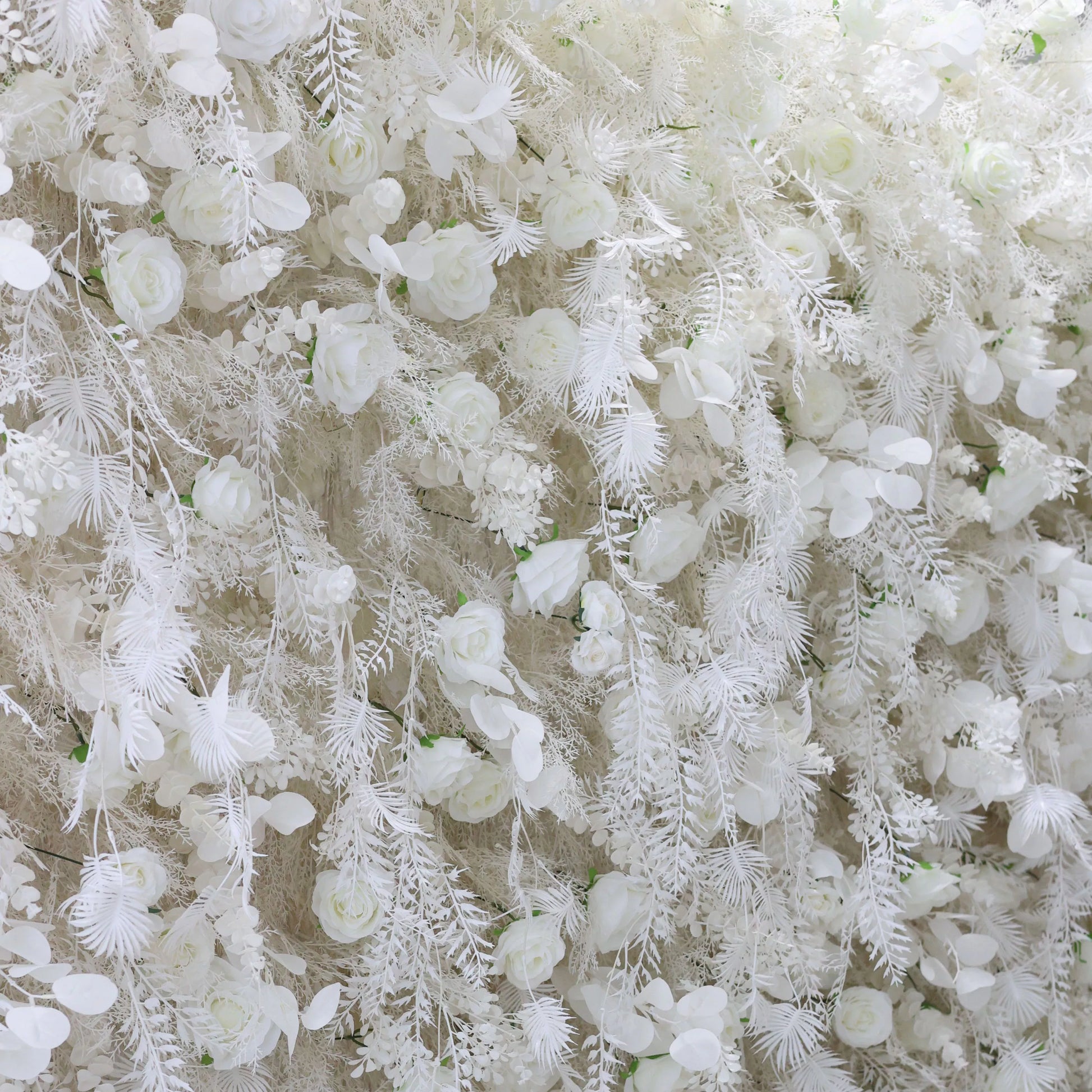 ValarFlowers white floral wall with roses peonies hydrangeas and feathered ferns for wedding backdrop photo booth event decor